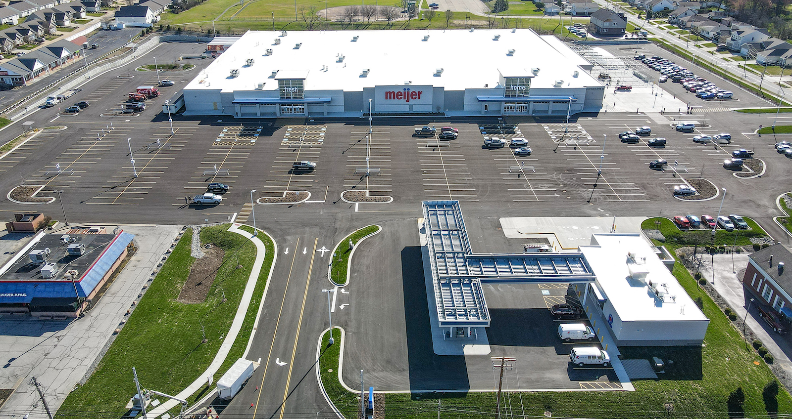 An aerial shot of the meijer building and parking lot with parked cars throughout the lot.