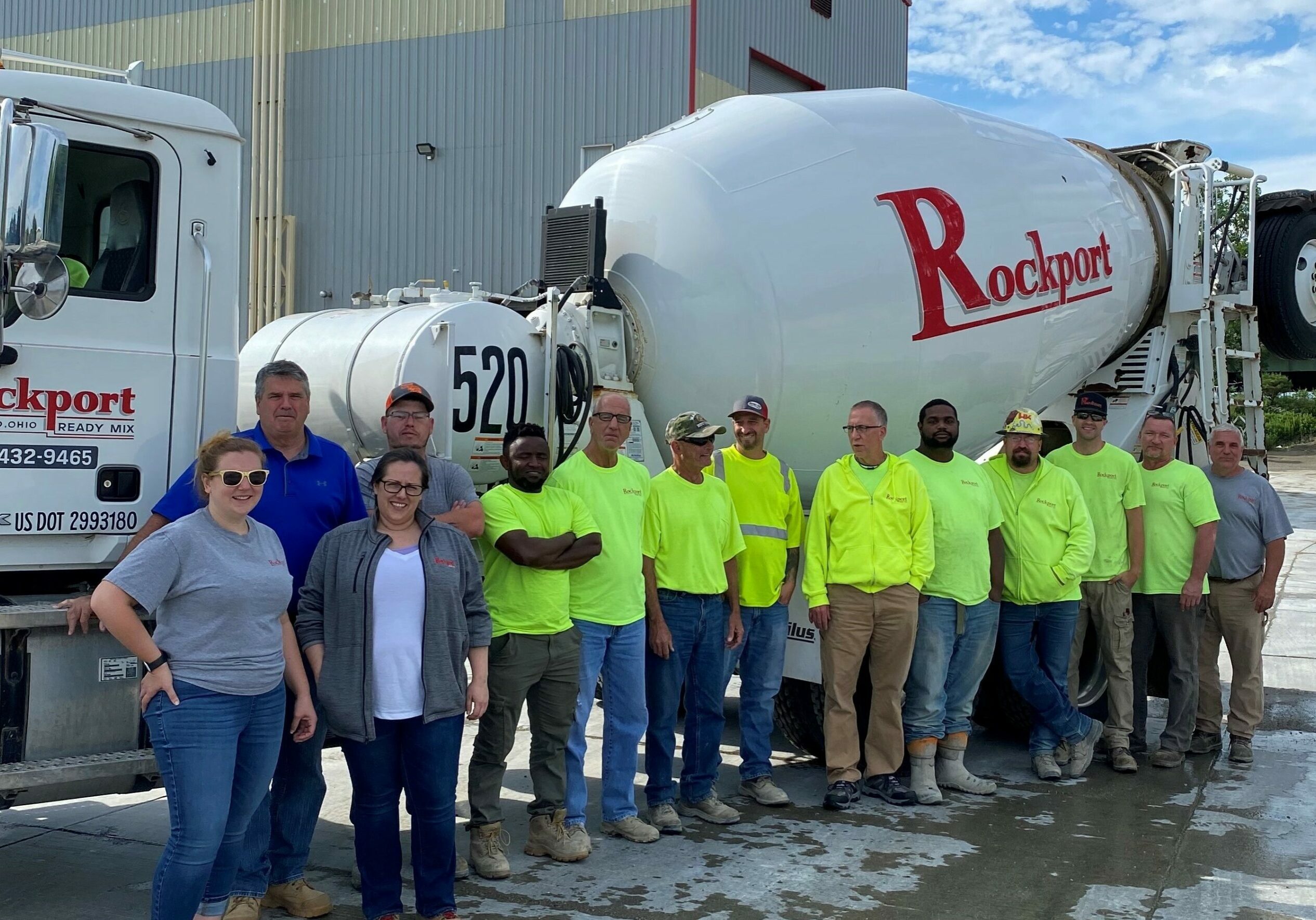 A team of crew members and employees stands in front of a white cement truck with the Rockport Ready Mix logo